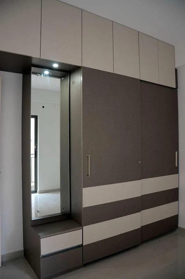 Modern wardrobe with sliding doors, mirror, and storage, designed for contemporary bedrooms.