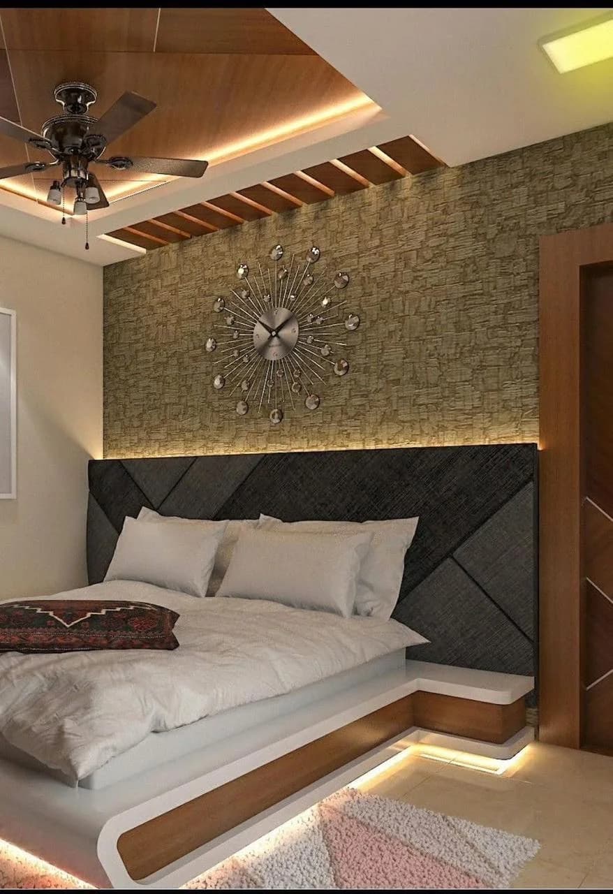 Modern bedroom with platform bed, geometric headboard, starburst clock, and ceiling fan.