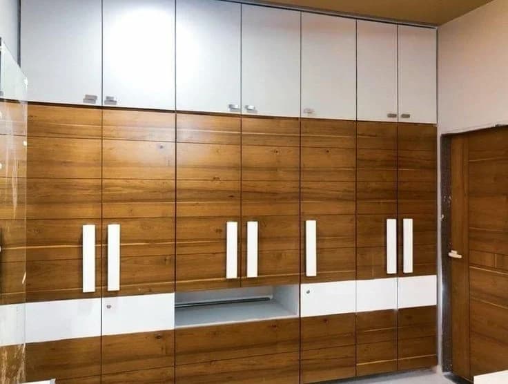 Modern wardrobe with woodgrain and white panels, vertical handles.