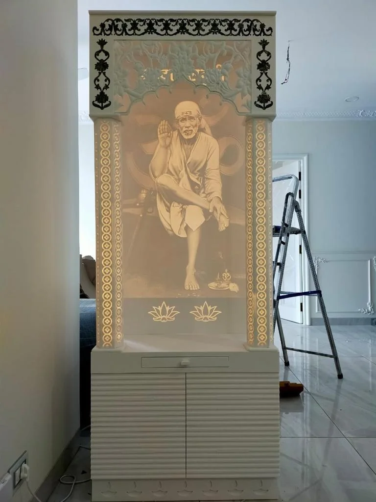 Illuminated Sai Baba temple cabinet in white with ornate details.